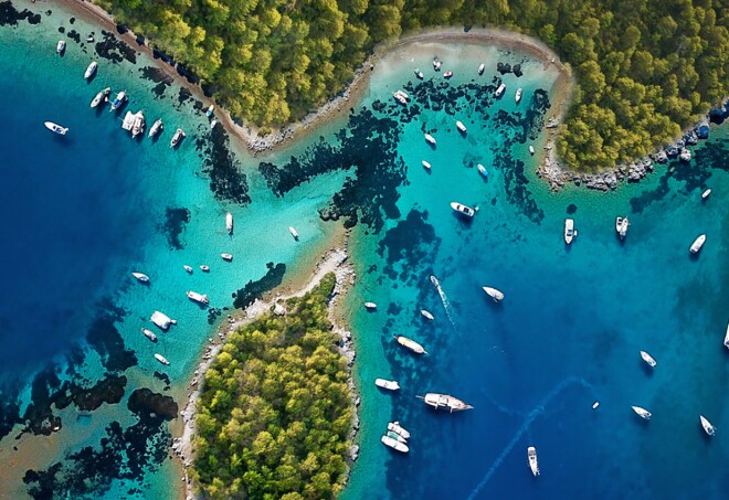 An arial view of the brilliant blue ocean and green foliage of Turkiye's Turquoise Coast