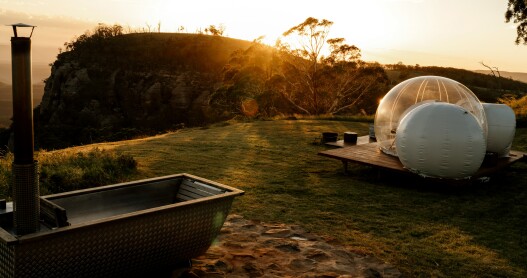 Sunset in Australia with a bubble tent and outdoor bath in the foreground