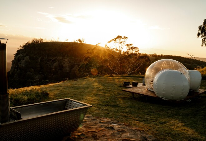 Sunset in Australia with a bubble tent and outdoor bath in the foreground