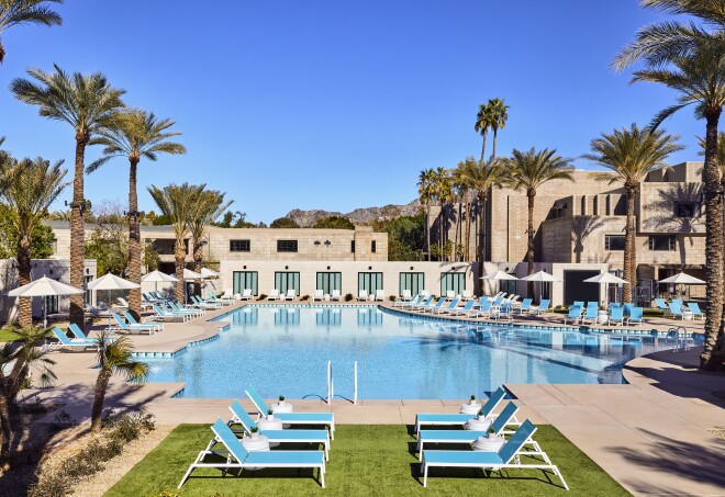 The Paradise Pool flanked by blue lawn chairs and palm trees at the Arizona Biltmore in Phoenix, Arizona