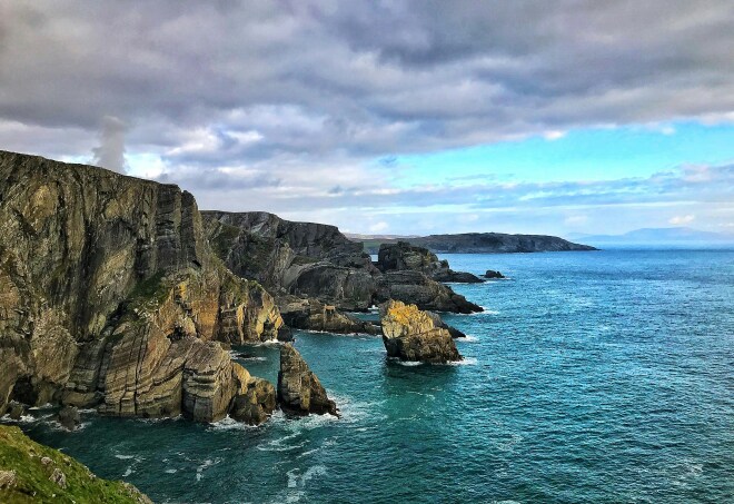 A view of the tall, rocky cliffs over the ocean in Mizen Head, Cork County, Ireland